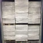 Stacked white plastic bales inside a shipping container