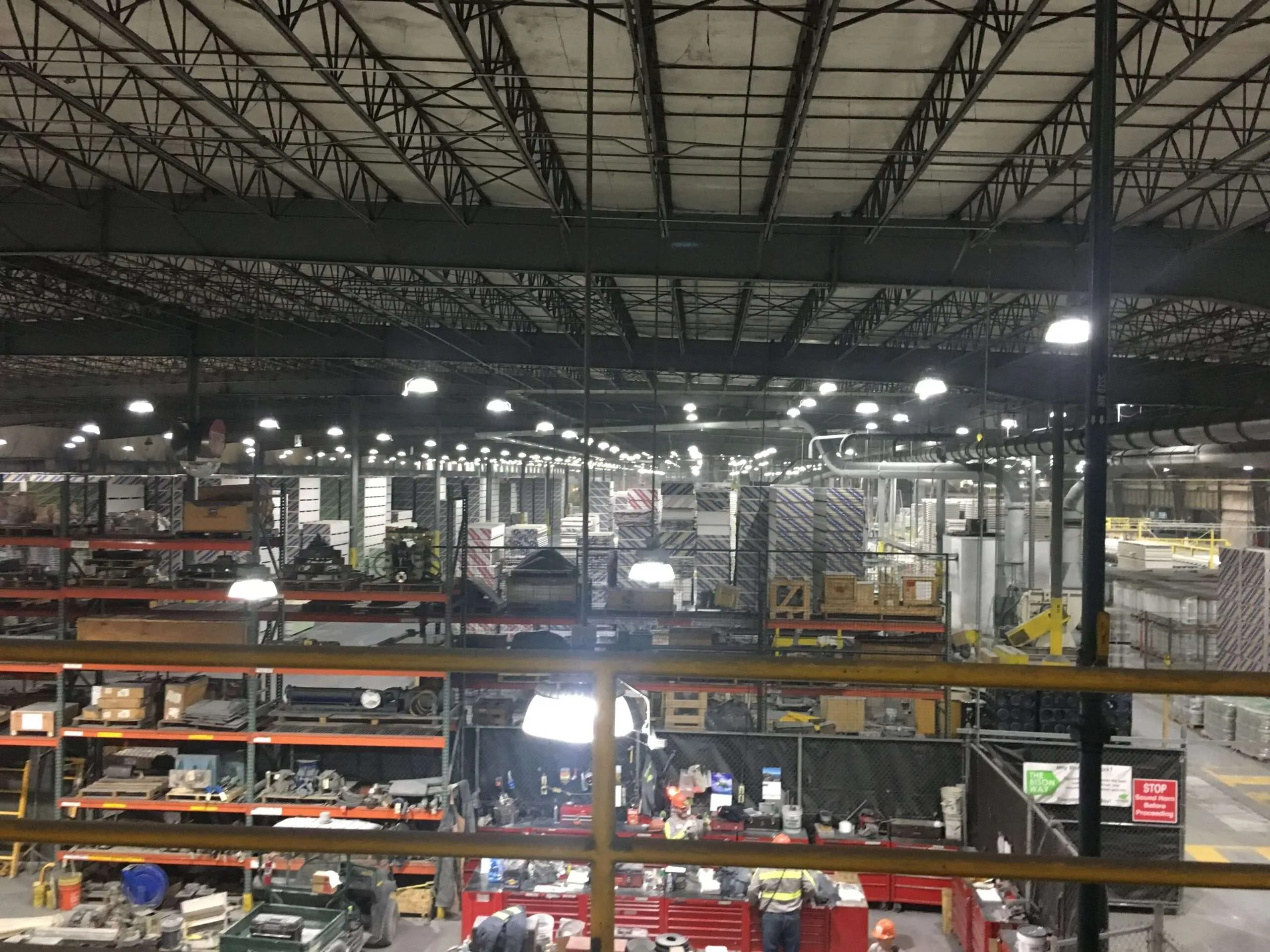 Workers in a large industrial warehouse with equipment