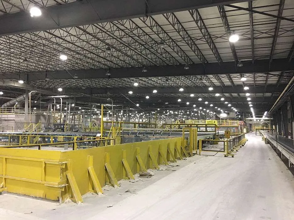 Large industrial factory with yellow safety barriers